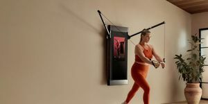 femeie blondă în ținută portocalie de fitness antrenament de forță cu sală de gimnastică de acasă tonal