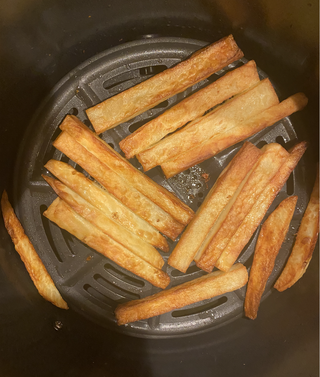 imagine de sus a coșului de gătit al friteuzei ninja air max xl, care conține în mare parte cartofi prăjiți tăiați manual maro auriu